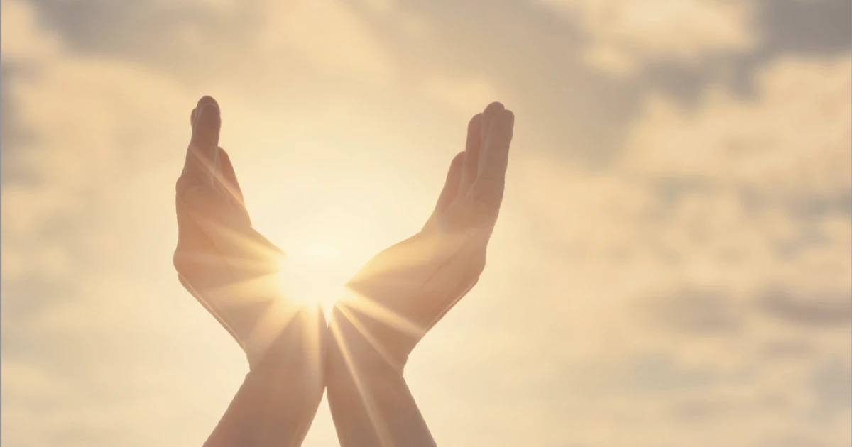 Hands in sky framing sun